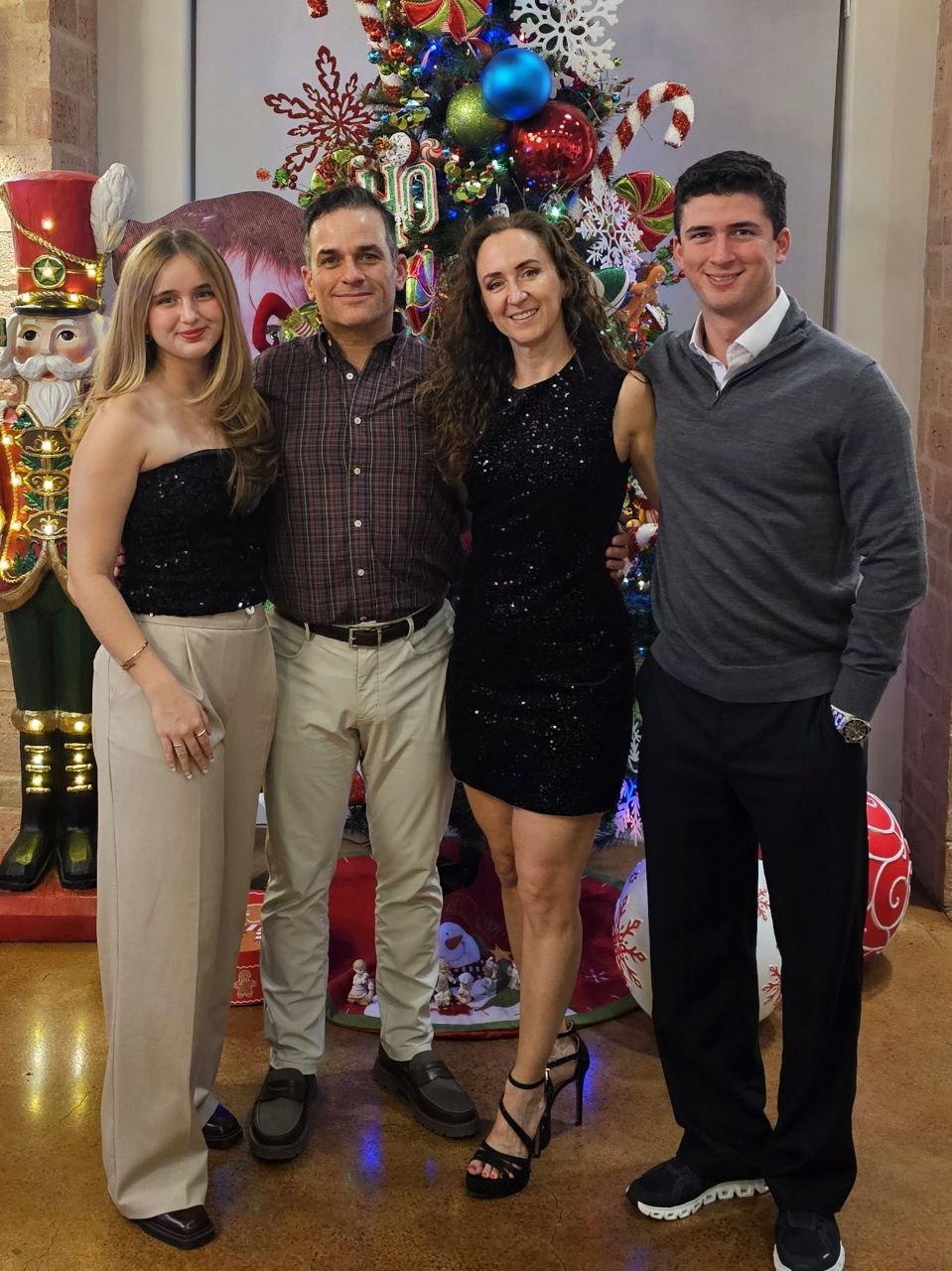 The Kauachi family posing together in front of a Christmas tree.